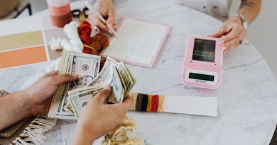 A creative workspace featuring a hands-on money counting and budgeting scene.